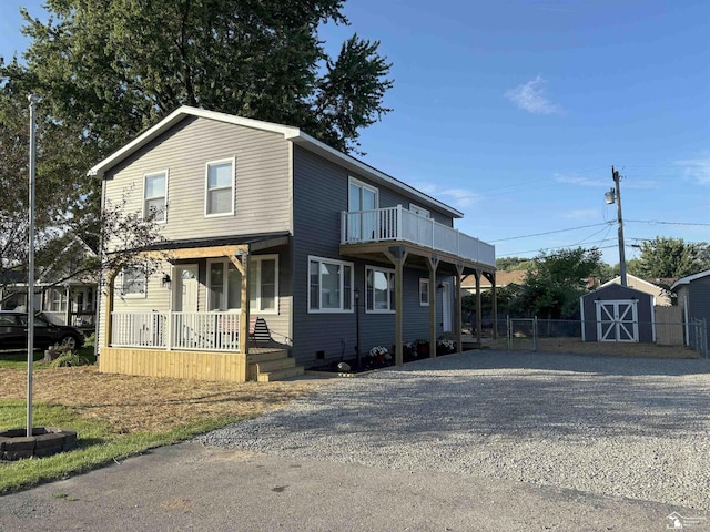 3315 9th St, Monroe, MI 48162 - view of front of home with a storage unit, gravel driveway, a porch, and a balcony