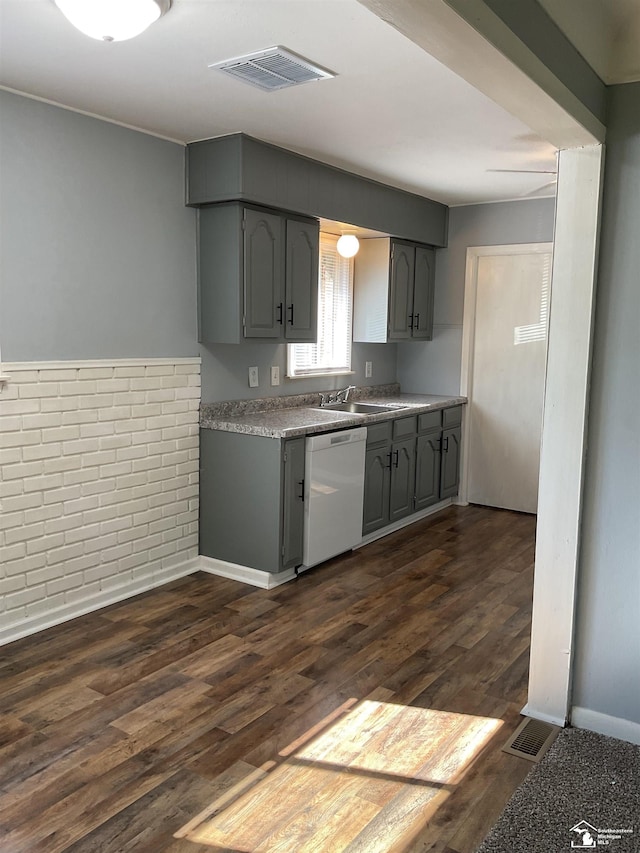 1503 Philomene Blvd, Lincoln Park, MI 48146 - kitchen with white dishwasher, gray cabinets, dark wood-style flooring, light countertops, and brick wall