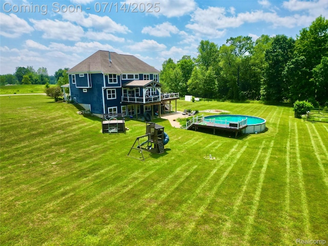 4385 Nelson Scott Dr, Holly, MI 48442 - back of property featuring a deck, an outdoor pool, and a lawn