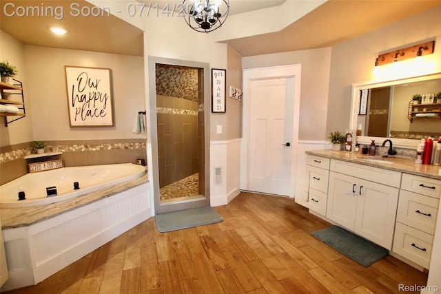4385 Nelson Scott Dr, Holly, MI 48442 - bathroom with a garden tub, tiled shower, vanity, a chandelier, and wood finished floors
