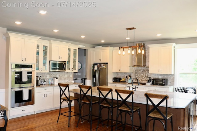 4385 Nelson Scott Dr, Holly, MI 48442 - kitchen featuring stainless steel appliances, wall chimney exhaust hood, a kitchen bar, backsplash, and recessed lighting