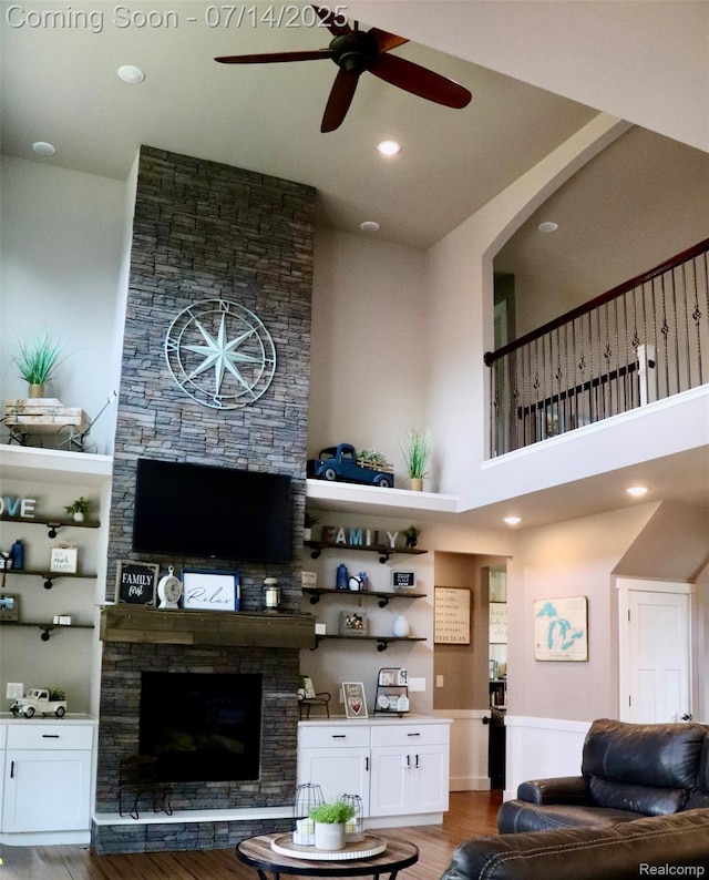 4385 Nelson Scott Dr, Holly, MI 48442 - living room featuring a ceiling fan, a stone fireplace, wood finished floors, and a towering ceiling