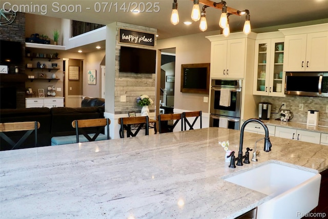 4385 Nelson Scott Dr, Holly, MI 48442 - kitchen with stainless steel appliances, decorative backsplash, white cabinets, and glass insert cabinets