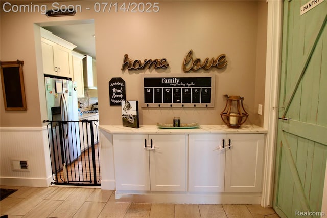 4385 Nelson Scott Dr, Holly, MI 48442 - bar with freestanding refrigerator, wall chimney exhaust hood, and wainscoting