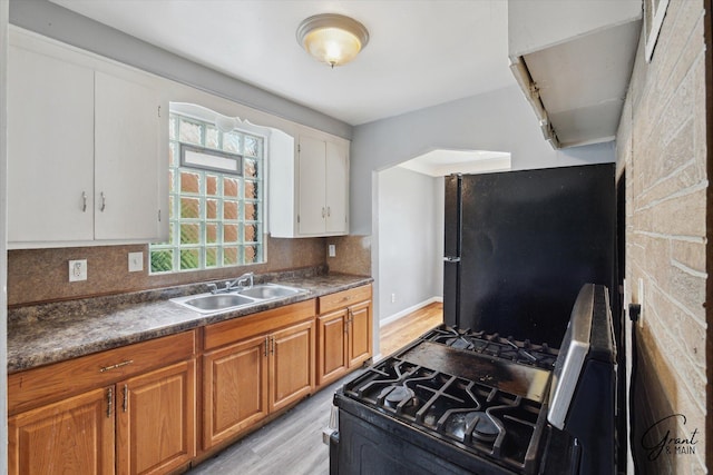19007 Kentfield St, Detroit, MI 48219 - kitchen featuring range with gas stovetop, freestanding refrigerator, light wood finished floors, and decorative backsplash