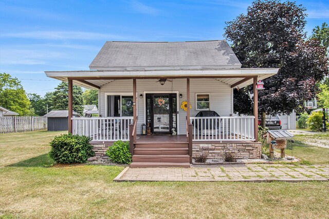 515 Locust St, Howard City, MI 49329 - bungalow-style house with covered porch, roof with shingles, and a storage unit