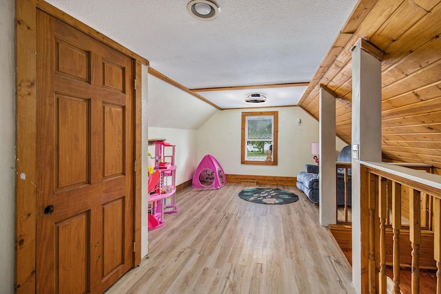 515 Locust St, Howard City, MI 49329 - bonus room featuring light wood-type flooring, vaulted ceiling, and a textured ceiling