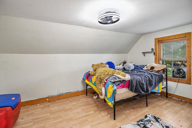 515 Locust St, Howard City, MI 49329 - bedroom with wood finished floors, vaulted ceiling, and a textured ceiling