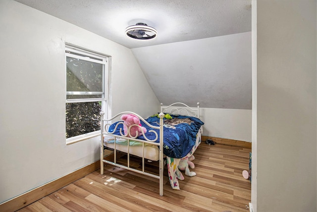 515 Locust St, Howard City, MI 49329 - bedroom with wood finished floors, vaulted ceiling, and a textured ceiling