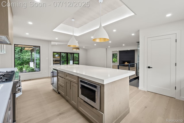 3539 Walbri Dr, Bloomfield Hills, MI 48304 - kitchen featuring stainless steel appliances, light wood-style floors, beverage cooler, light countertops, and decorative light fixtures