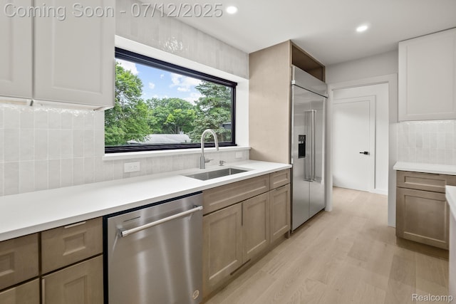 3539 Walbri Dr, Bloomfield Hills, MI 48304 - kitchen featuring stainless steel dishwasher, built in refrigerator, tasteful backsplash, light countertops, and light wood-type flooring