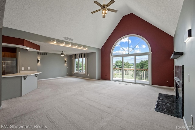 3410 Adams Shore Dr, Waterford, MI 48329 - unfurnished living room featuring a ceiling fan, high vaulted ceiling, light colored carpet, a high end fireplace, and a textured ceiling