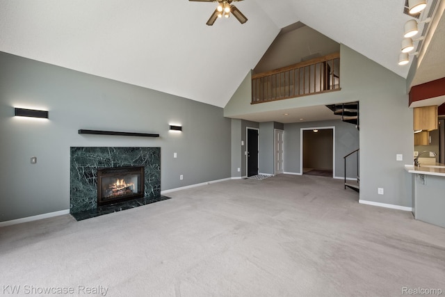 3410 Adams Shore Dr, Waterford, MI 48329 - unfurnished living room with high vaulted ceiling, a ceiling fan, carpet flooring, a premium fireplace, and stairway