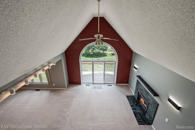 3410 Adams Shore Dr, Waterford, MI 48329 - unfurnished living room featuring a textured ceiling, a tiled fireplace, a ceiling fan, lofted ceiling, and carpet