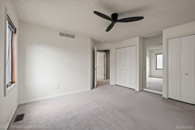 3410 Adams Shore Dr, Waterford, MI 48329 - unfurnished bedroom featuring multiple closets, carpet, a textured ceiling, and a ceiling fan