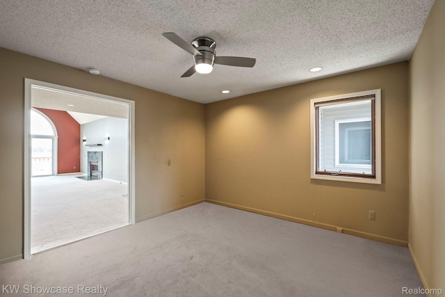 3410 Adams Shore Dr, Waterford, MI 48329 - empty room featuring carpet, a ceiling fan, a fireplace, a textured ceiling, and recessed lighting