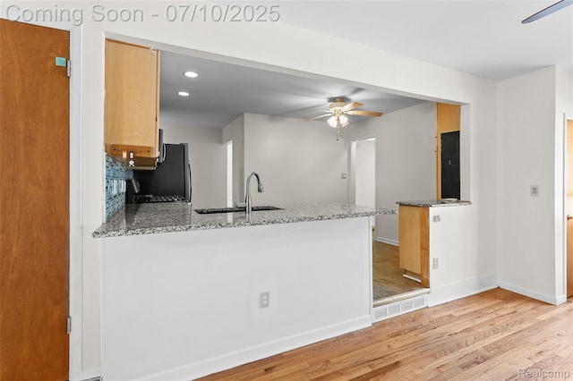 1868 Treadwell St, Westland, MI 48186 - kitchen with a peninsula, ceiling fan, freestanding refrigerator, light wood-type flooring, and light stone countertops