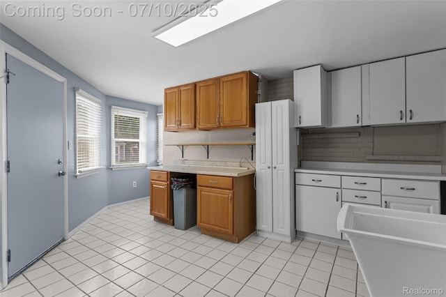 1868 Treadwell St, Westland, MI 48186 - kitchen with light countertops, brown cabinets, light tile patterned floors, and backsplash