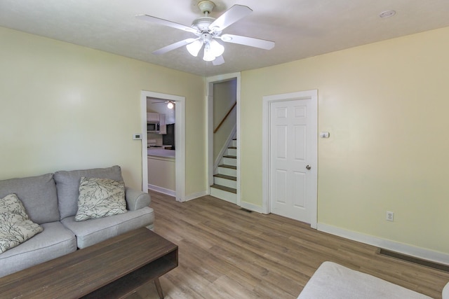 637 Prospect Ave NE, Grand Rapids, MI 49503 - living area featuring ceiling fan, wood finished floors, and stairs