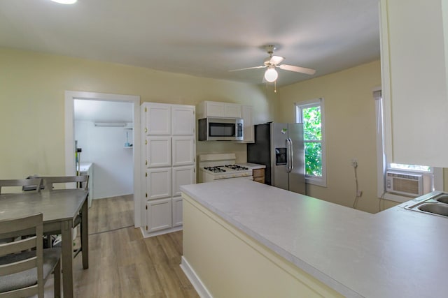 637 Prospect Ave NE, Grand Rapids, MI 49503 - kitchen with appliances with stainless steel finishes, light wood-style flooring, ceiling fan, white cabinetry, and a peninsula