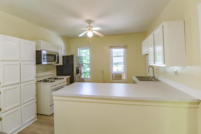 637 Prospect Ave NE, Grand Rapids, MI 49503 - kitchen with stainless steel appliances, a peninsula, a ceiling fan, and white cabinets