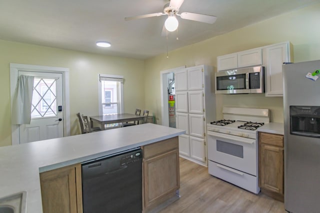 637 Prospect Ave NE, Grand Rapids, MI 49503 - kitchen featuring stainless steel appliances, light wood-type flooring, light countertops, white cabinets, and a ceiling fan