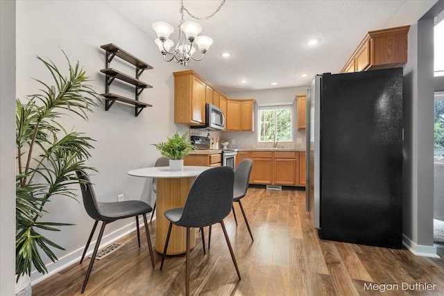 2948 Stoney Creek Ct, Hudsonville, MI 49426 - kitchen with stainless steel appliances, light countertops, light wood-style floors, a chandelier, and recessed lighting