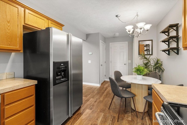 2948 Stoney Creek Ct, Hudsonville, MI 49426 - kitchen featuring appliances with stainless steel finishes, wood finished floors, light countertops, a chandelier, and a textured ceiling