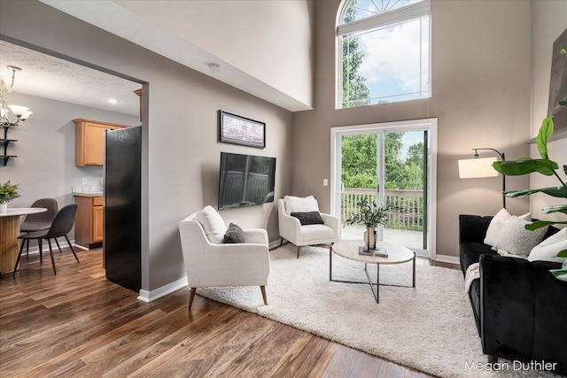 2948 Stoney Creek Ct, Hudsonville, MI 49426 - living room featuring dark wood-style flooring, a chandelier, and a towering ceiling