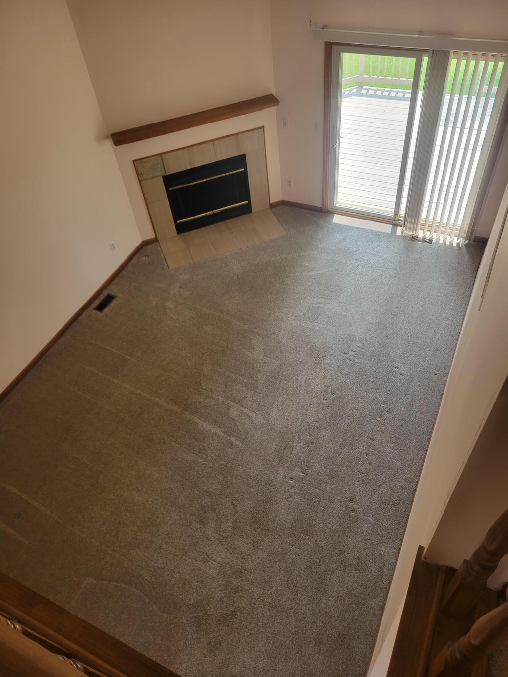 15430 Windmill Dr, Macomb, MI 48044 - unfurnished living room with a fireplace and carpet flooring