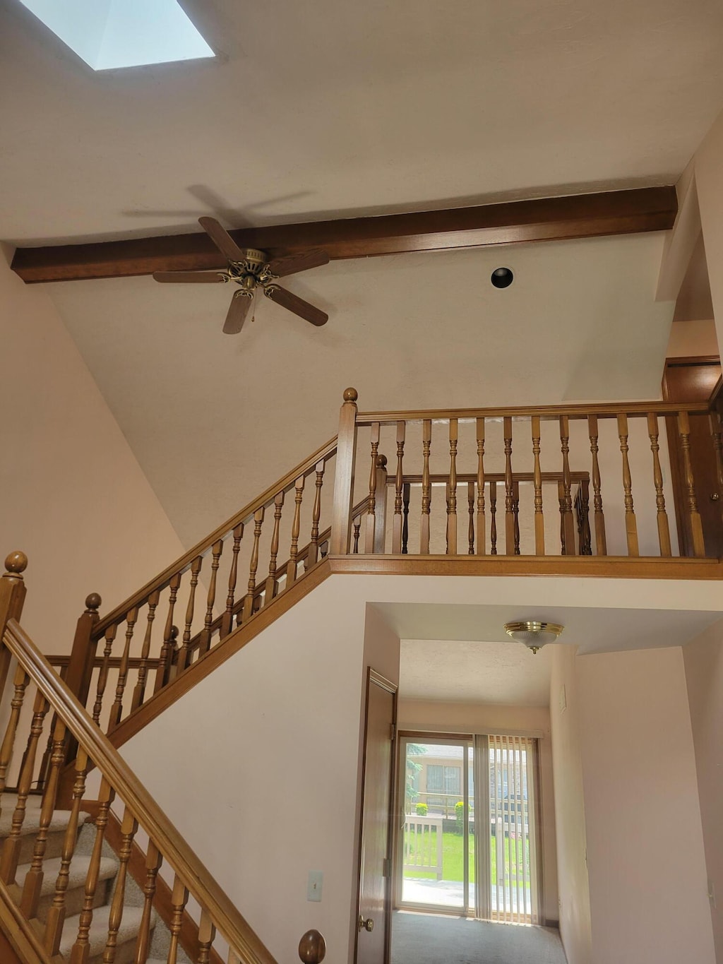 15430 Windmill Dr, Macomb, MI 48044 - staircase featuring beam ceiling, a skylight, ceiling fan, and high vaulted ceiling