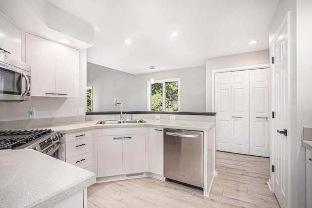 1721 Fountainview Ct SE, Caledonia, MI 49316 - kitchen with appliances with stainless steel finishes, a peninsula, recessed lighting, light countertops, and white cabinets