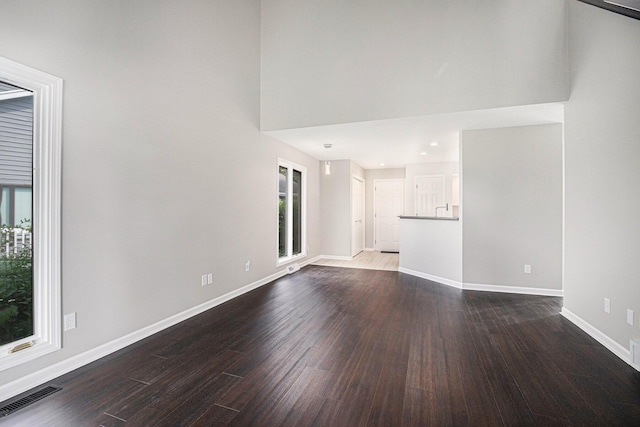 1721 Fountainview Ct SE, Caledonia, MI 49316 - unfurnished living room with healthy amount of natural light, dark wood-type flooring, and a high ceiling