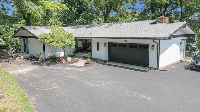191 S Lake Doster Dr, Plainwell, MI 49080 - single story home with roof with shingles, a chimney, asphalt driveway, and an attached garage