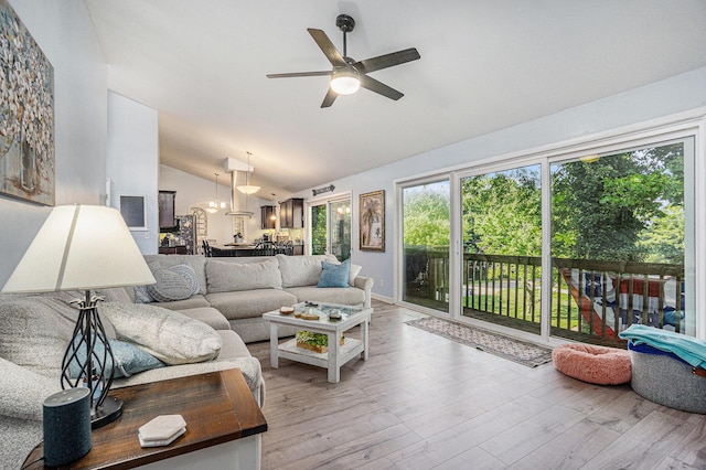 191 S Lake Doster Dr, Plainwell, MI 49080 - living room with lofted ceiling, a chandelier, a ceiling fan, and light wood-type flooring