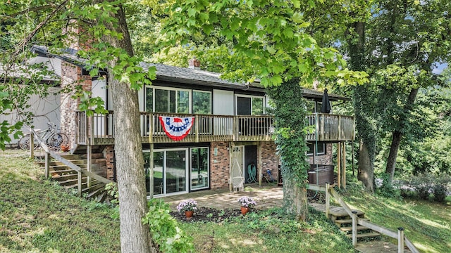 191 S Lake Doster Dr, Plainwell, MI 49080 - back of property with a deck, a patio area, stairs, a chimney, and brick siding