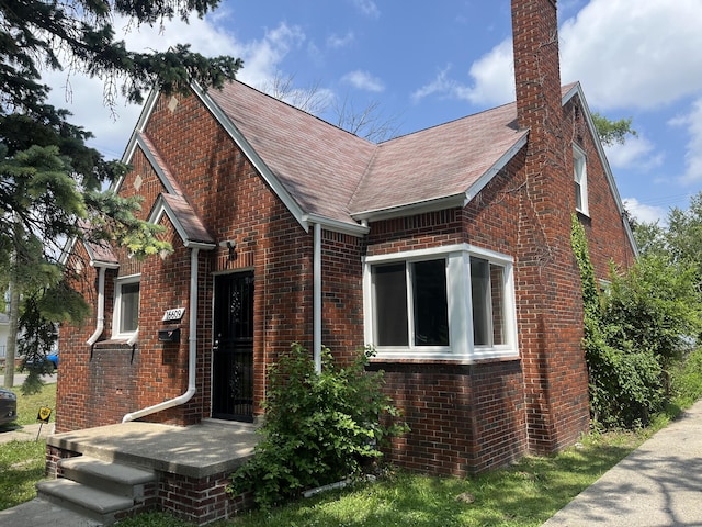 16609 Edmore Dr, Detroit, MI 48205 - tudor-style house featuring brick siding, a chimney, and a shingled roof