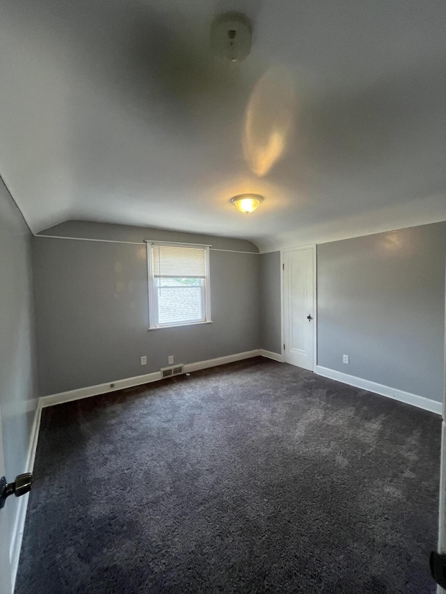 16609 Edmore Dr, Detroit, MI 48205 - spare room with vaulted ceiling and dark carpet