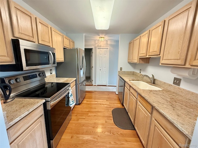 6426 Club Ct W, Grand Blanc, MI 48439 - kitchen featuring appliances with stainless steel finishes, light brown cabinets, light wood-style floors, and light stone counters