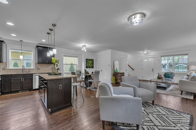 715 Gardenia Ave, Royal Oak, MI 48067 - kitchen featuring open floor plan, a kitchen breakfast bar, a kitchen island, decorative backsplash, and dark wood-style flooring