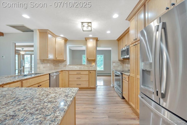 1526 Rulane Dr, Lapeer, MI 48446 - kitchen featuring appliances with stainless steel finishes, light brown cabinetry, backsplash, light wood-type flooring, and recessed lighting