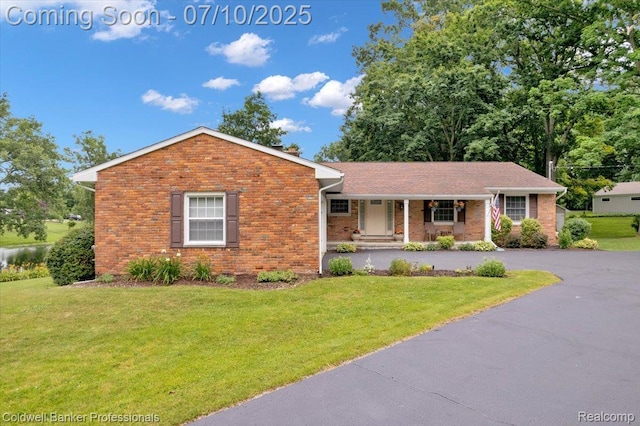 1526 Rulane Dr, Lapeer, MI 48446 - view of front of property with a porch, brick siding, and a front lawn