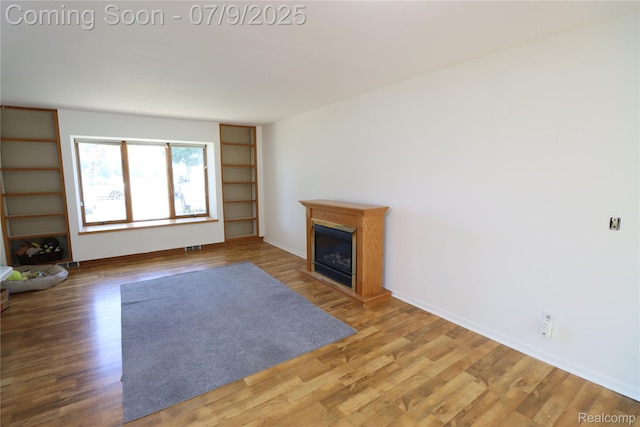 9360 Gale Rd, Goodrich, MI 48438 - unfurnished living room with wood finished floors and a fireplace