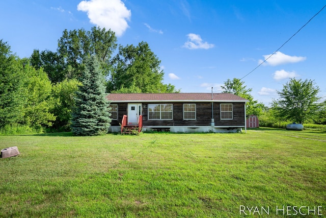 5886 W Clarksville Rd, Lake Odessa, MI 48849 - view of front of property featuring a front yard, a storage unit, and entry steps