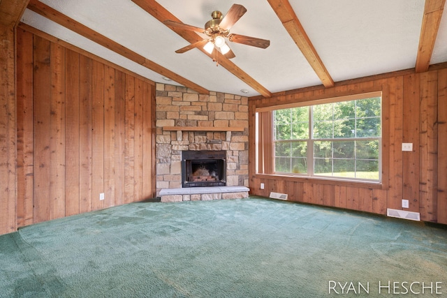 5886 W Clarksville Rd, Lake Odessa, MI 48849 - unfurnished living room featuring wood walls, carpet floors, a stone fireplace, and a ceiling fan