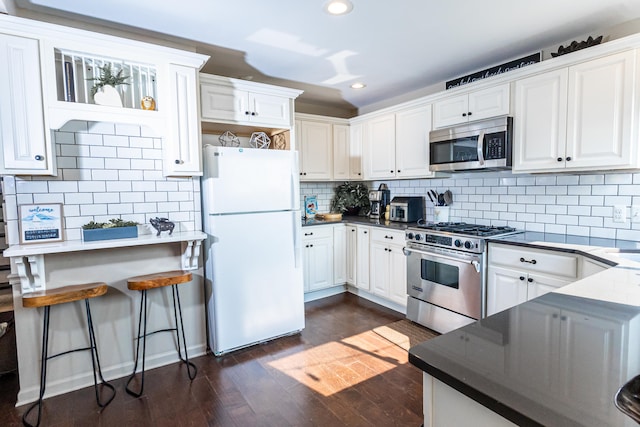 22515 E 10 Mile Rd, Saint Clair Shores, MI 48080 - kitchen featuring stainless steel appliances, recessed lighting, dark wood-style floors, tasteful backsplash, and white cabinetry