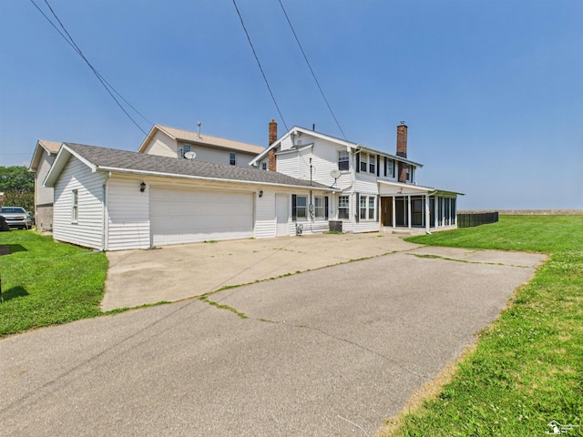 4356 14th St, Luna Pier, MI 48157 - back of house featuring a sunroom, a garage, a lawn, and a chimney