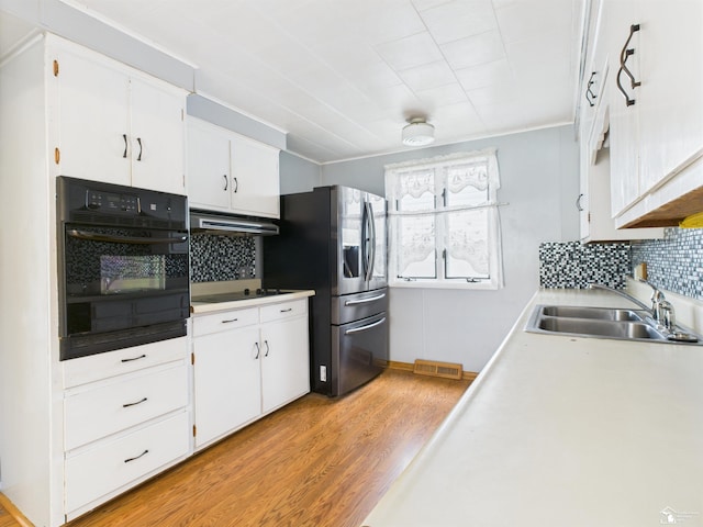 4356 14th St, Luna Pier, MI 48157 - kitchen featuring black appliances, light wood-style flooring, tasteful backsplash, and white cabinets