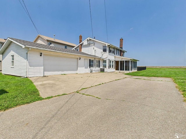 4356 14th St, Luna Pier, MI 48157 - view of front of home featuring a sunroom, concrete driveway, a front yard, a garage, and roof with shingles