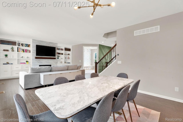 2962 Iowa Dr, Troy, MI 48083 - dining area featuring a chandelier, stairway, dark wood-type flooring, and built in shelves